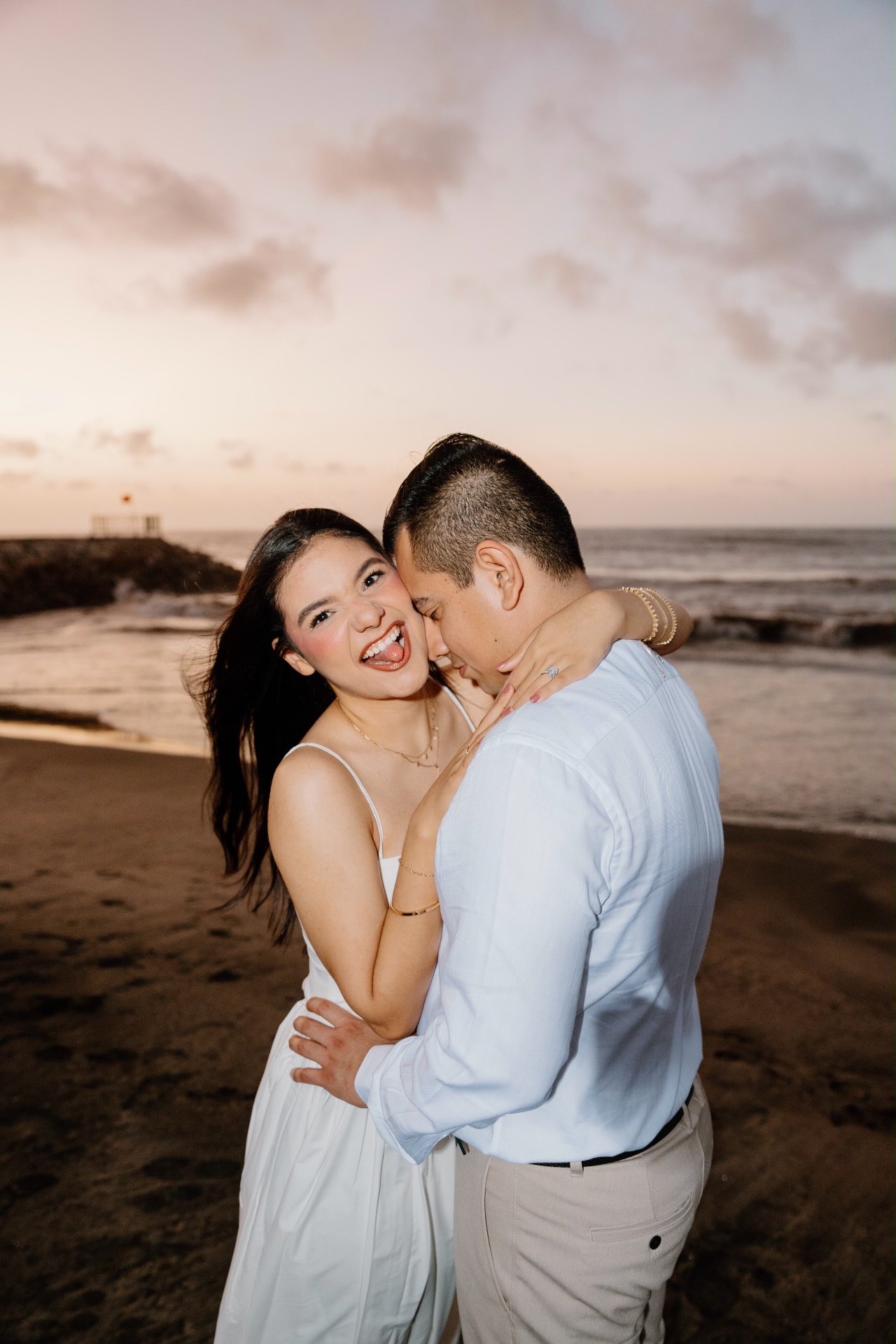 Emily y Franklin riendo en la playa al atardecer